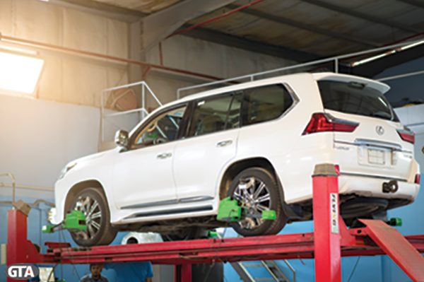 Four-post wheel alignment check on a Lexus SUV